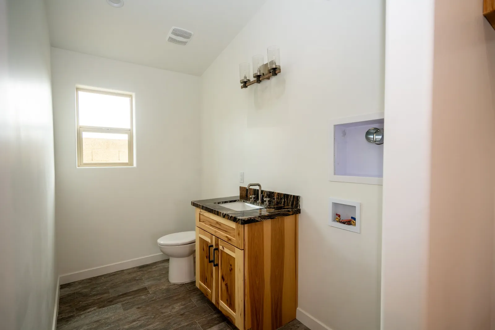 Small finished bathroom with a wood vanity on a Masizo job