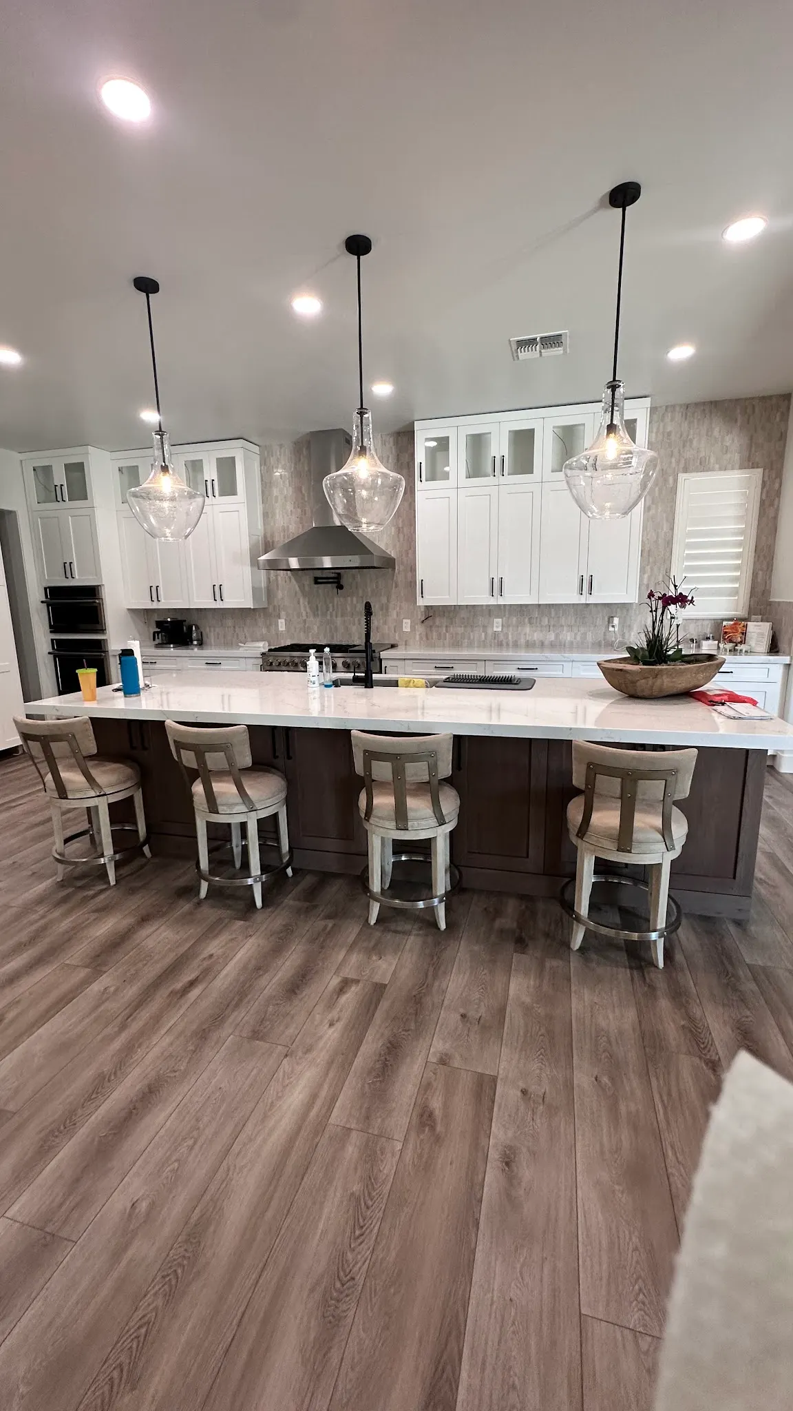 Remodeled kitchen with a long island, bar stools and pendant lights on a Masizo job