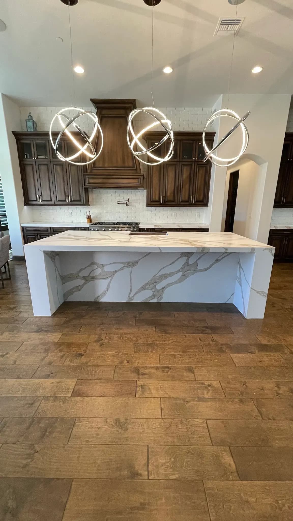 Waterfall island and dark wood cabinets in a customer's finished kitchen