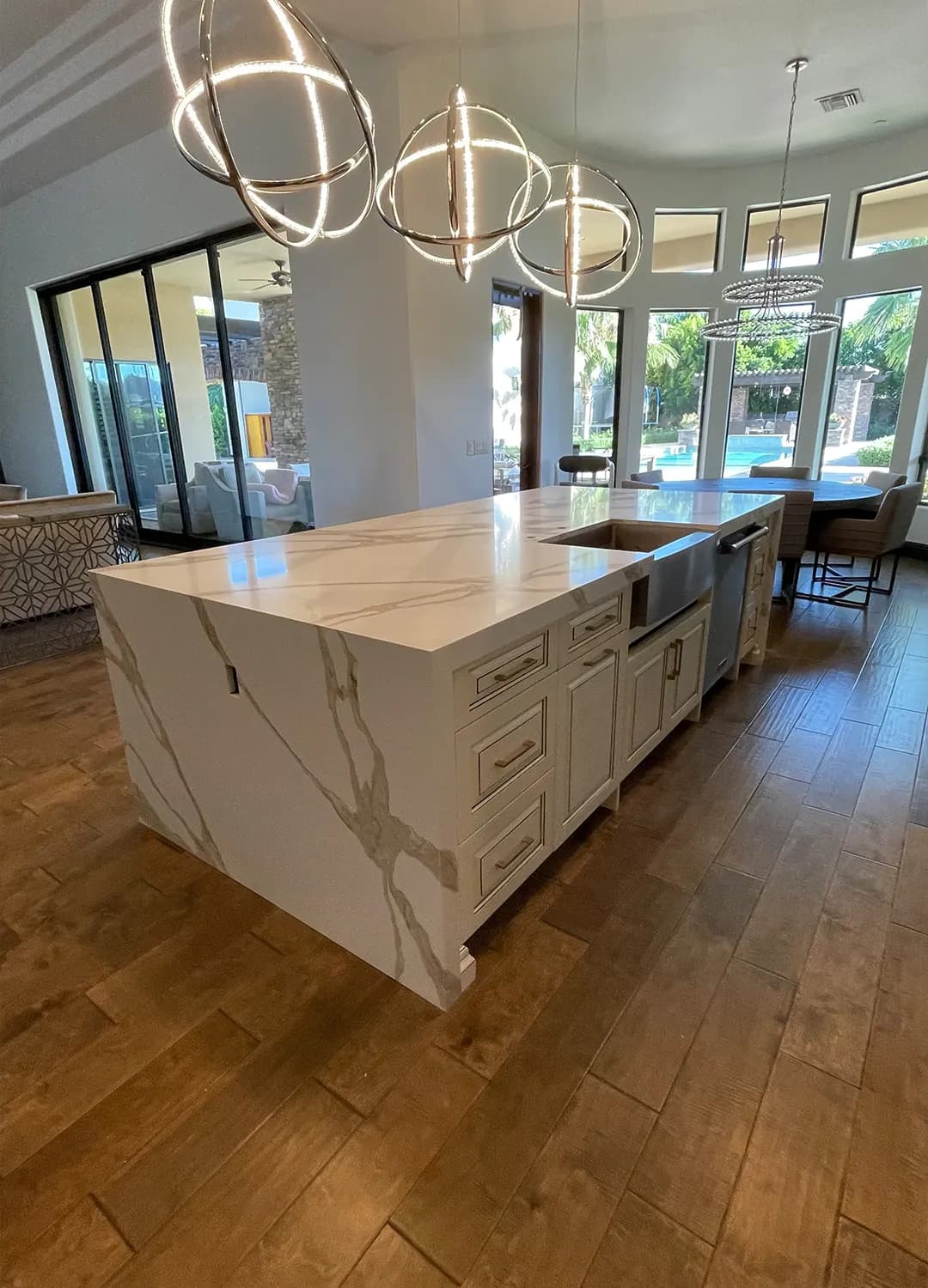 White waterfall island with a sink in an open Masizo kitchen