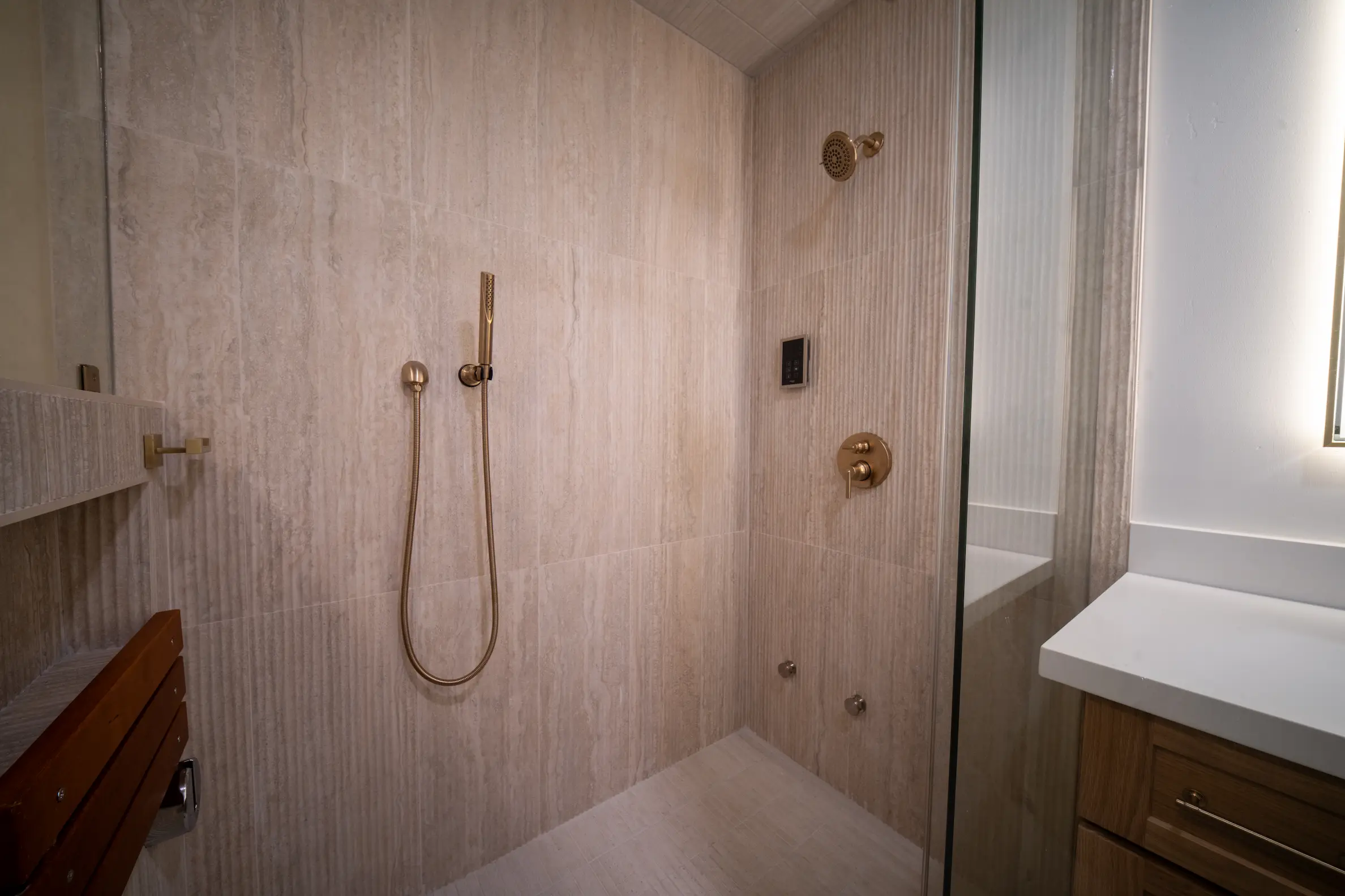 Walk-in shower with large tile and a handheld shower head