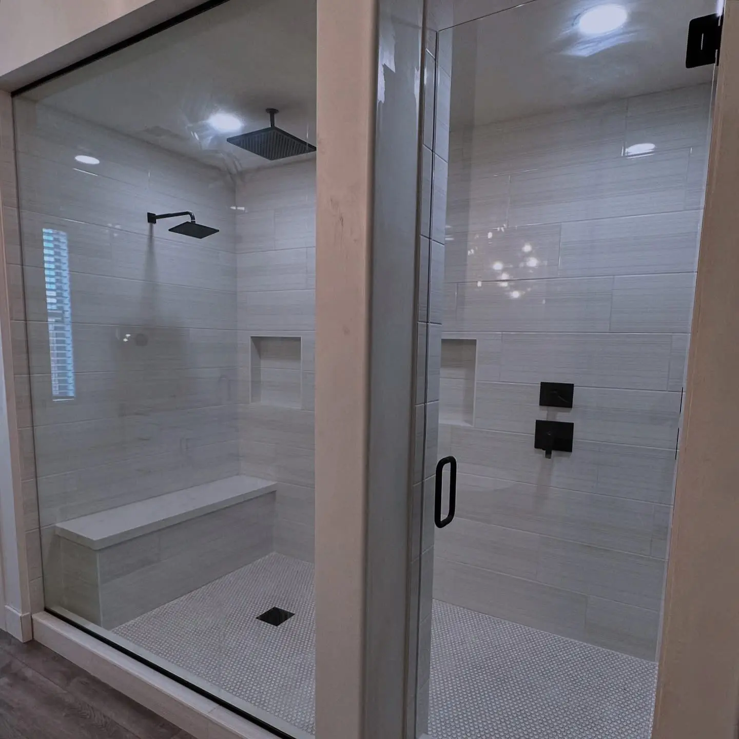 Glass walk-in shower with a built-in bench