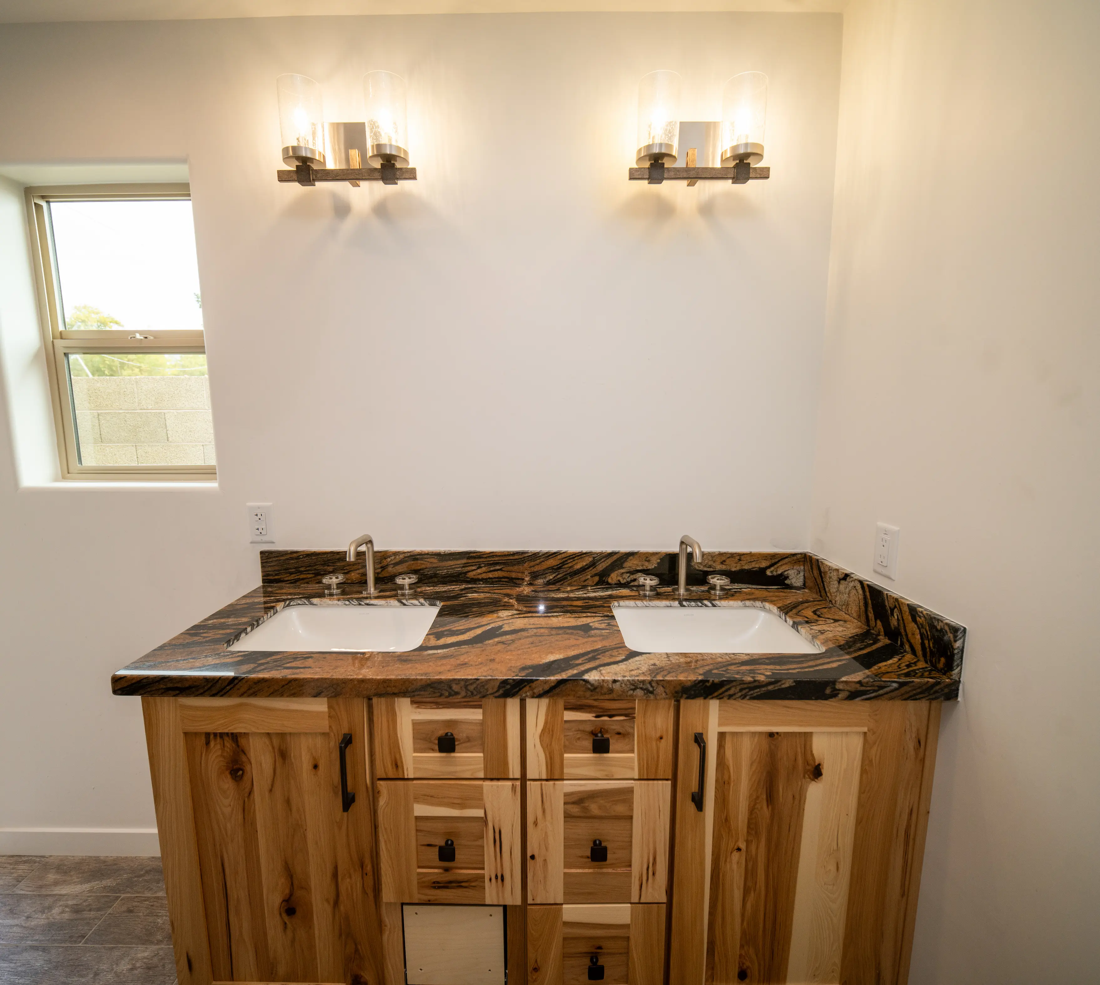 Double vanity with hickory cabinets and a granite countertop
