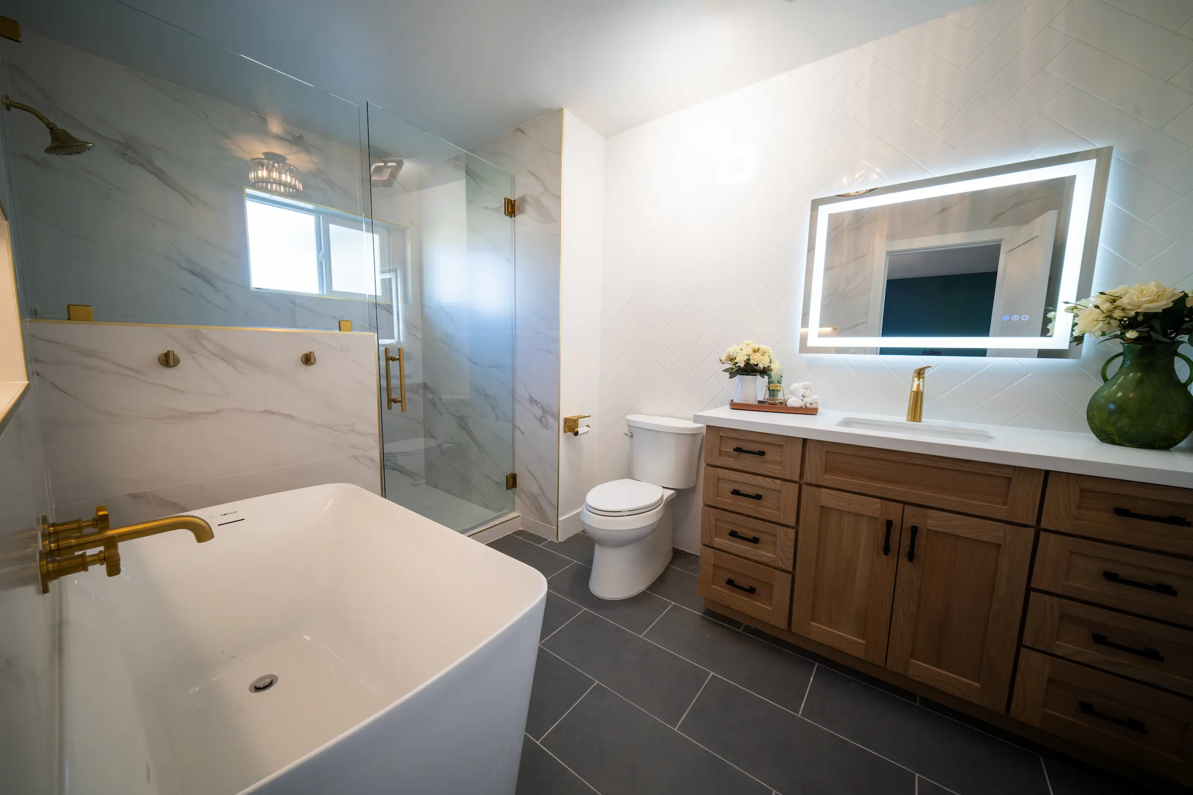 Bathroom remodel with a freestanding tub, glass shower and wood vanity