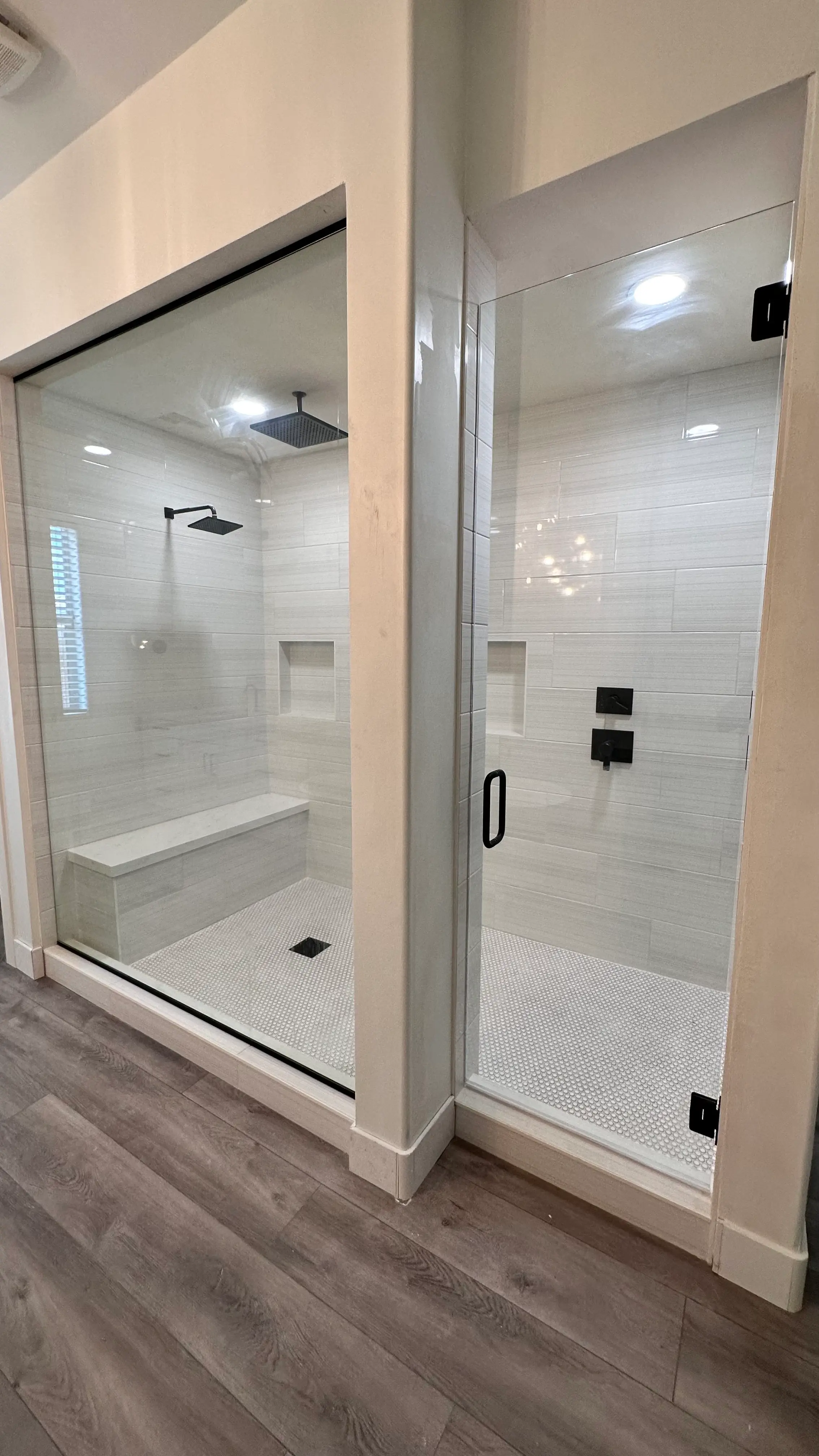 Walk-in shower with a glass door and white tile
